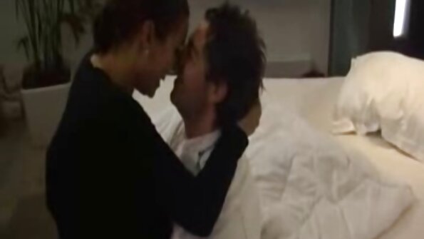 Seorang berambut perang dan si rambut coklat sedang bercium antara satu sama lain dalam video lesbian